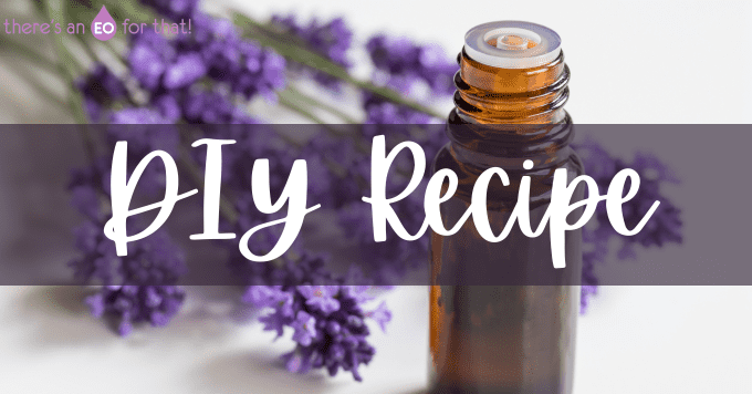 an essential oil bottle next to lavender flowers